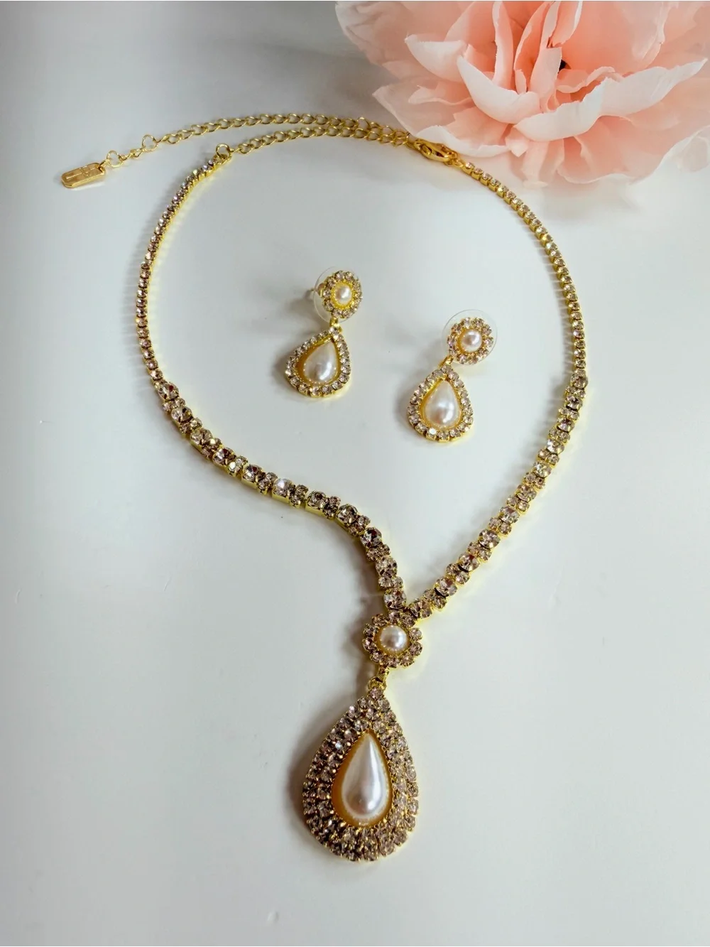Elegant gold-tone necklace with earrings featuring a white teardrop pearl pendan